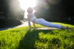 Beautiful sportive woman doing yoga meditation in a park -  Girl relaxing with serene expression outdoors